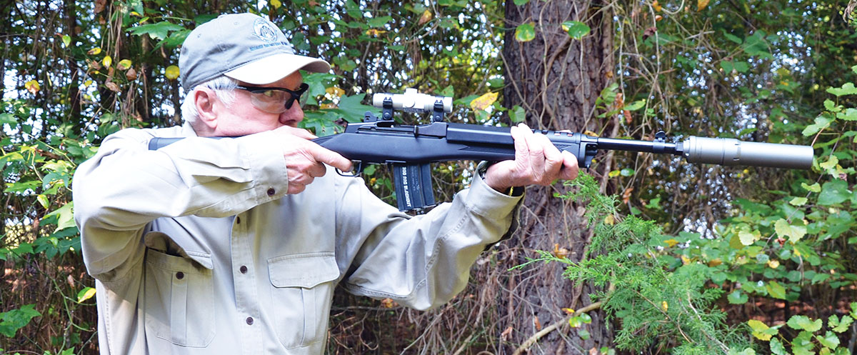 A Swarovski 3-9x scope was used on the Mini-14 when accuracy testing for this report but as shown here, it usually wears an  Ultradot with a one-inch tube. When shooting from a benchrest, the rifle was supported by a Caldwell rabbit ear bag filled  with sand at the rear and a Lyman Match Bag resting on that company’s quick elevation-adjustable Bag Jack at the front. An  extremely effective Nosler SR-30ALTi suppressor was also used.